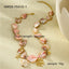 Pink shell-style necklace with gold-tone marine charms and measurement labels