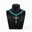 Turquoise-colored beaded necklace with ornate cross pendant on a black display bust