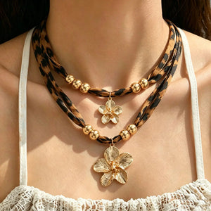 Layered leopard-print cord necklace with gold-tone beads and two flower pendants