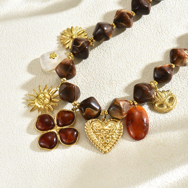 Close-up of brown necklace beads with gold-tone heart and flower charms