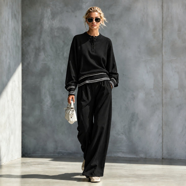 Black button-neck top and wide-leg pants set with striped trim, worn by a model