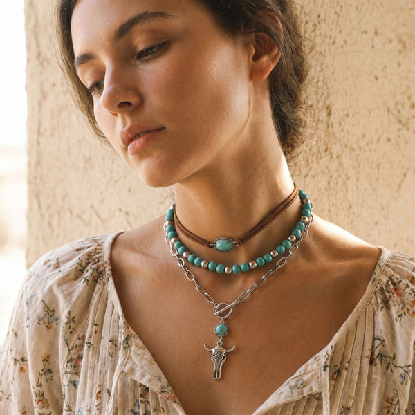Layered turquoise-colored necklaces with brown choker and silver-tone charm