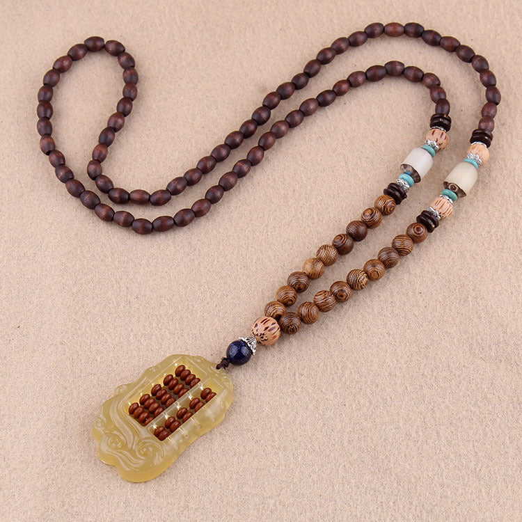 Brown beaded necklace with pale rectangular pendant and contrasting accent beads