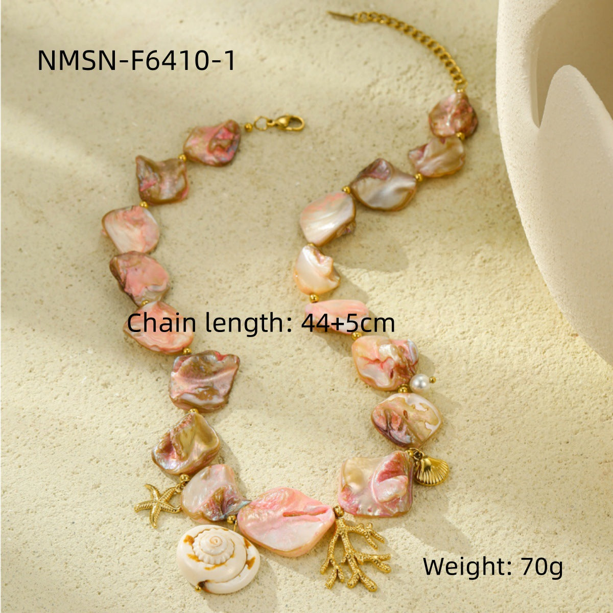 Pink shell-style necklace with gold-tone marine charms and measurement labels