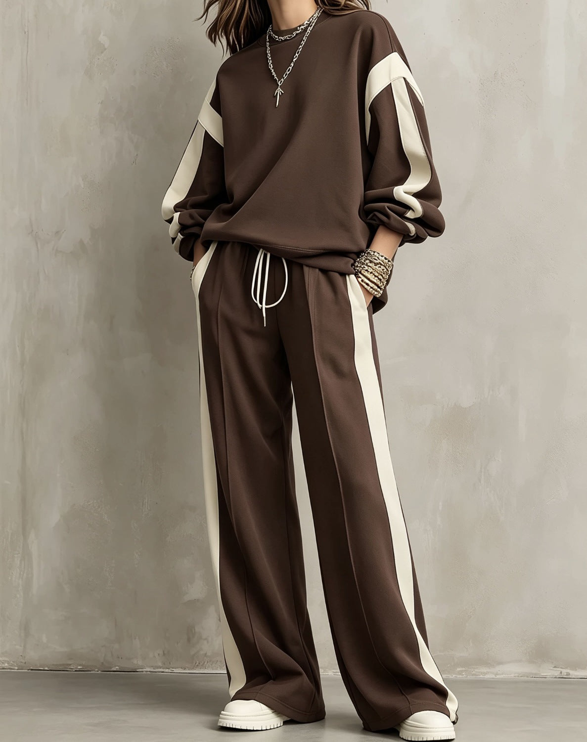 Brown sweatshirt and wide-leg pants set with cream contrast panels, worn by a model
