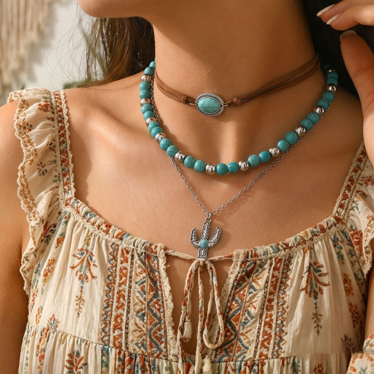 Turquoise-colored beaded choker with brown cord and layered silver-tone pendant