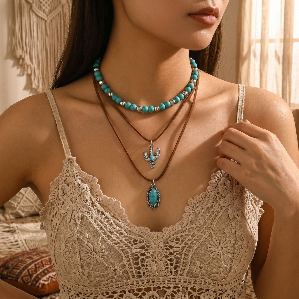 Turquoise-colored beaded necklace with layered chain and blue teardrop pendant