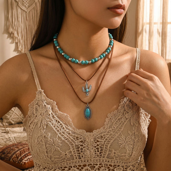 Turquoise-colored beaded necklace with layered chain and blue teardrop pendant