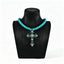 Turquoise-colored beaded necklace with ornate cross pendant on a black display bust