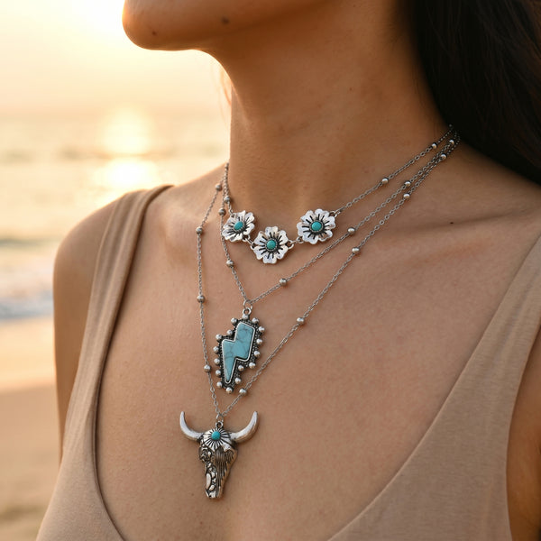 Silver-tone floral and turquoise-colored layered necklaces with a bull head pendant