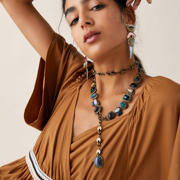 Model wearing a long layered necklace with multicolor oval accents