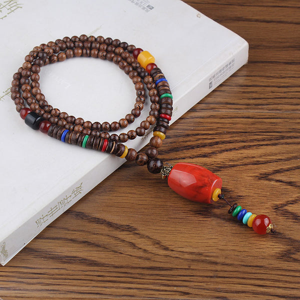 Brown beaded necklace with bright red drop pendant and multicolor hanging beads