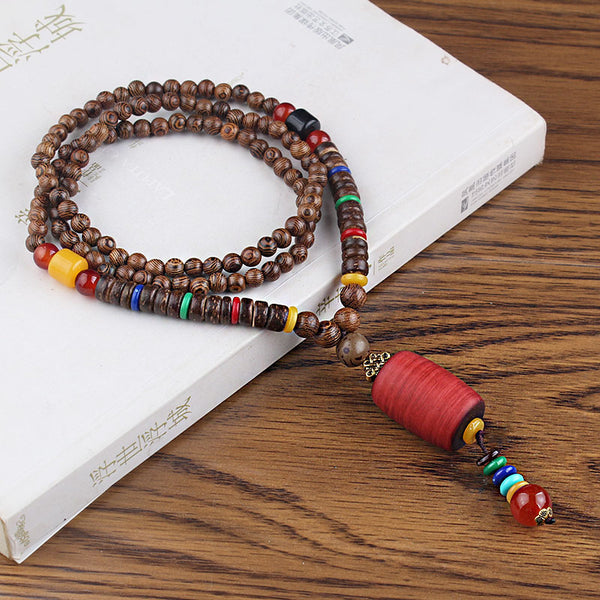 Brown beaded necklace with red cylindrical pendant and multicolor hanging beads