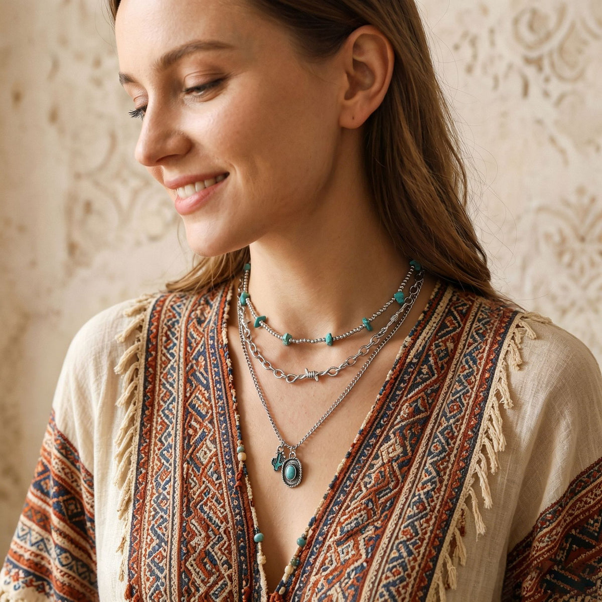 Layered silver-tone chains with turquoise-colored pendant, worn with a patterned top
