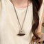 Brown bar pendant necklace on a long cord, worn with a cream top