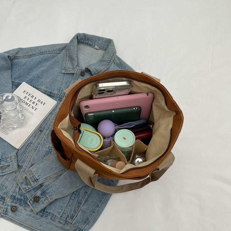 Canvas tote bag shown carried on shoulder
