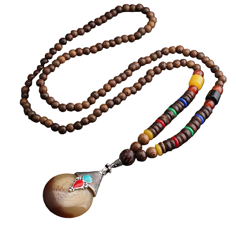 Long brown beaded necklace with round two-tone pendant and colorful accent beads