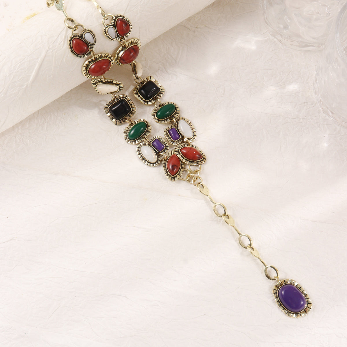 Close-up of the multicolor necklace accents, decorative settings and purple drop pendant
