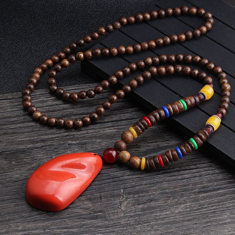 Long brown beaded necklace with multicolor discs and a red pendant