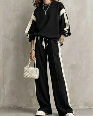 Black sweatshirt and wide-leg pants set with cream contrast panels, worn by a model