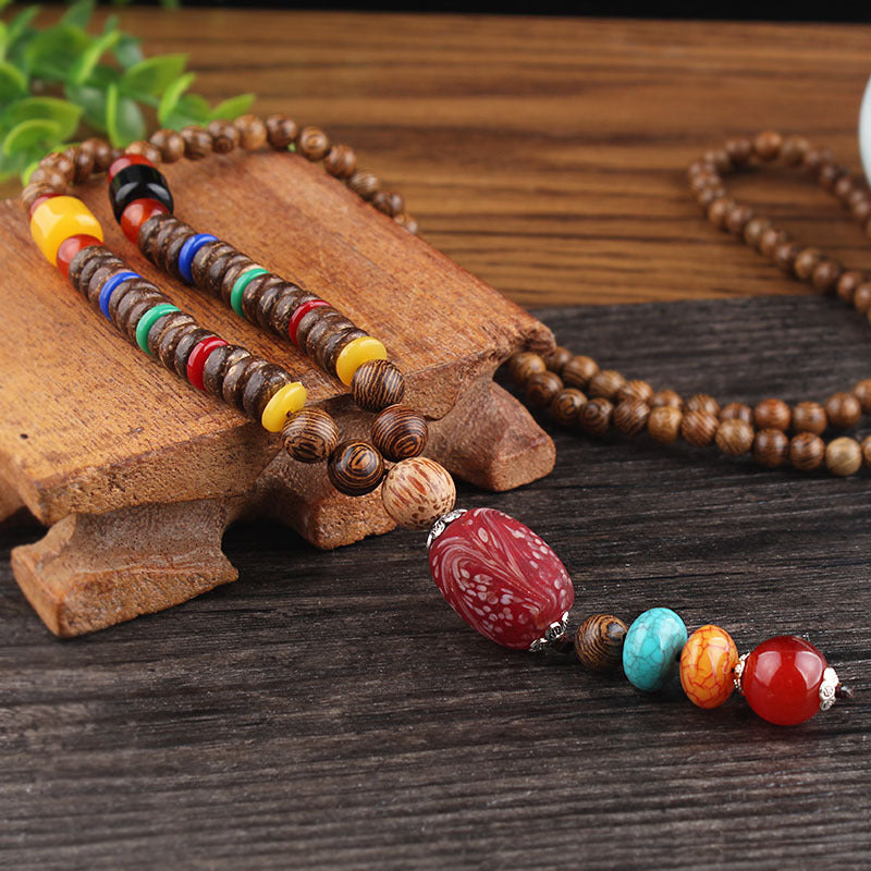 Close-up of necklace beads with red textured pendant and multicolor accents