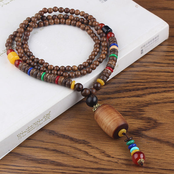 Brown beaded necklace with cylindrical tan pendant and multicolor accents