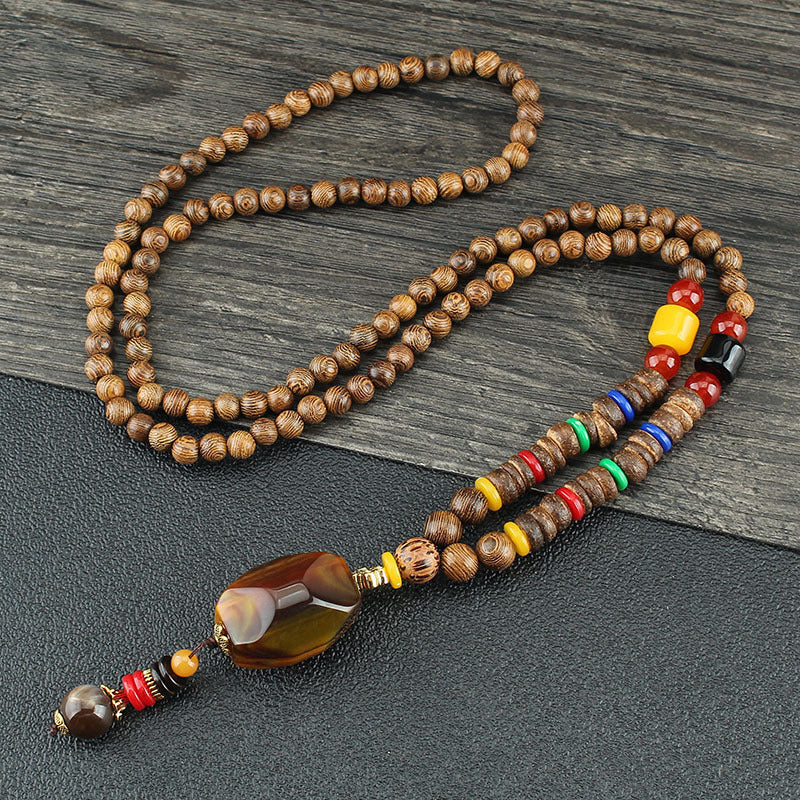 Brown beaded necklace with multicolor disc beads and an amber-colored drop pendant