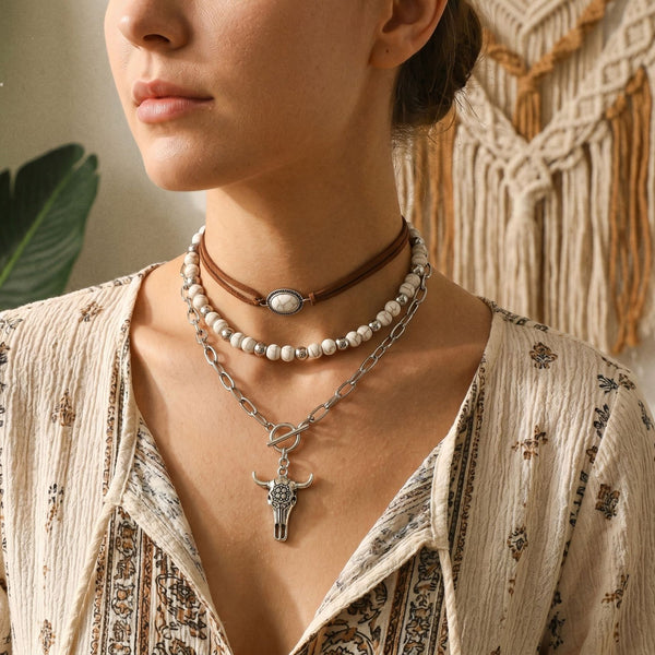 Layered pale beaded necklaces with brown choker and silver-tone cross pendant