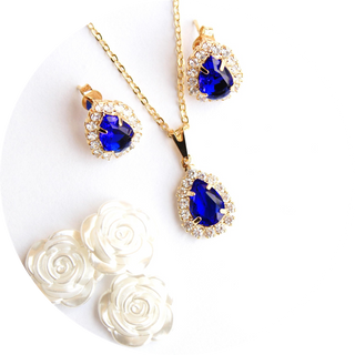 Jewelry set with blue gemstones and gold accents on a white background